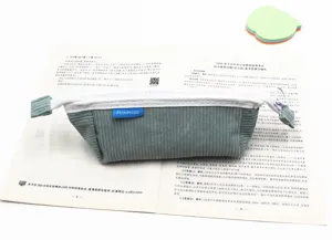 Primo piano di un astuccio in velluto a coste grigio-blu su un libro