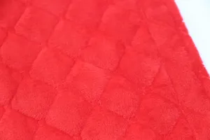 Close-up detail of red plush fabric with quilted diamond pattern for seat belt cover