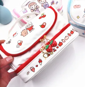 Vista dettagliata dei ciondoli a fragola e del design a doppio strato della borsa cosmetica bianca.