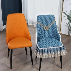 Dettaglio di un coprisedia trapuntato blu con rifiniture in pizzo su una sedia da pranzo