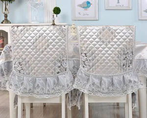 Quilted silver-grey dining chair covers with elegant lace ruffles and floral embroidery
