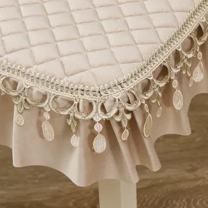 Dettaglio di pizzo dorato e velluto trapuntato su un elegante copritavolo