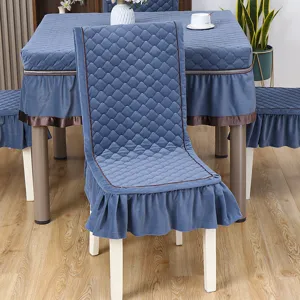 Dettaglio coprisedie trapuntati blu e tovaglia coordinata con volant per sala da pranzo