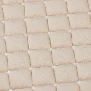 Dettaglio ravvicinato di tessuto felpato trapuntato beige con motivo quadrato per sedie