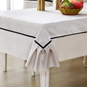 Vue détaillée d'une nappe blanche texturée avec bordure noire et coin drapé élégant