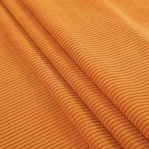 Close-up detail of orange corduroy fabric with textured ribbed pattern for chair covers.
