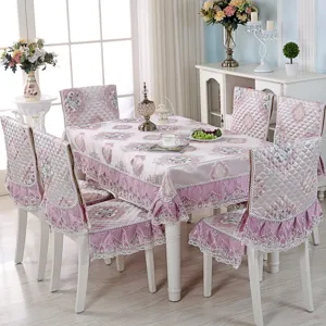 Elegant floral tablecloth and matching chair cover set in a bright dining room setting