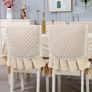Detailed view of quilted beige chair back covers with lace trim and pleated ruffle edge