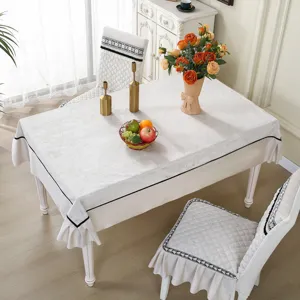 Ensemble de salle à manger avec housses de chaise matelassées blanches et nappe