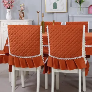 Detail view of orange quilted chair back covers and tablecloth with elegant lace trim
