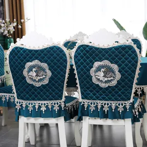 Détail des housses de chaise en velours bleu sarcelle avec broderie cygne élégante