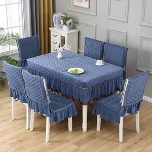 Vista dettagliata della tovaglia trapuntata blu polvere e dei coprisedia in una sala da pranzo