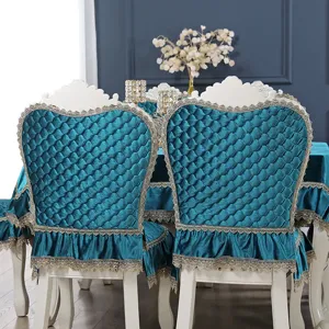 Elegant detailed view of quilted peacock blue velvet chair covers with ruffled lace trim.