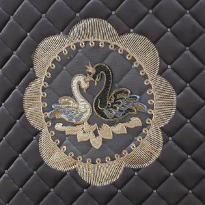 Primo piano dell'elegante ricamo a cigno sulla fodera della sedia in pelle trapuntata