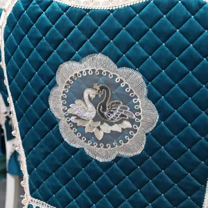Vue détaillée du motif cygne brodé sur une housse de chaise matelassée haut de gamme