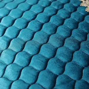 Macro view of luxurious teal velvet quilted chair cover fabric with elegant scalloped pattern