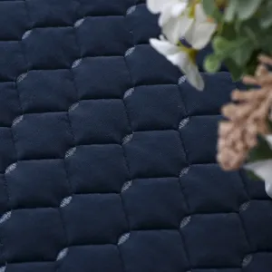 Primo piano di tessuto trapuntato blu navy con motivo a nido d'ape dettagliato.