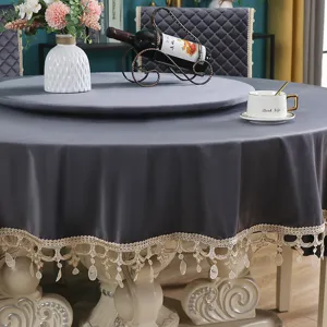 Dettaglio di tovaglia rotonda in velluto grigio con bordo in pizzo dorato elegante