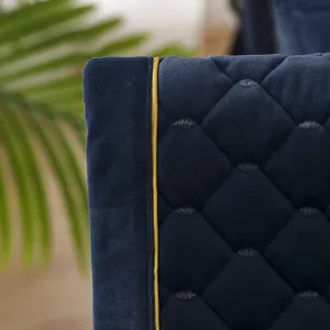 Dettaglio macro del coprisedia in velluto trapuntato blu navy con elegante profilo oro