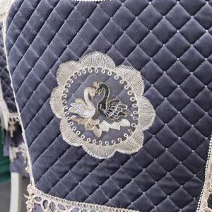Détail de la housse de chaise en velours matelassé avec broderie cygne et dentelle
