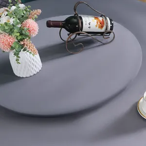 Dettaglio di una moderna tovaglia rotonda grigia in un elegante ambiente da pranzo.