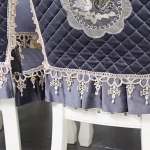 Gros plan sur housse de chaise en velours gris avec broderie et bordure en dentelle