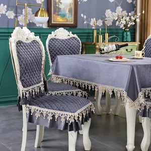 Détail de housses de chaise grises matelassées de style européen et nappe en dentelle.