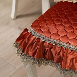Close-up of European-style velvet chair cushion with elegant golden lace trim.