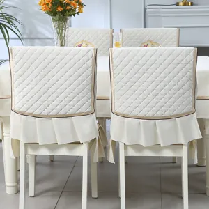 Detailed view of cream quilted dining chair back covers with elegant pleated ruffles
