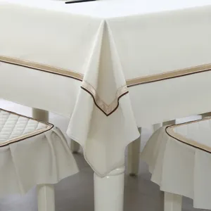 Close-up of cream tablecloth and matching chair covers with elegant ribbon trim
