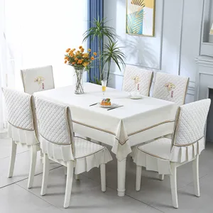 Close-up detail of cream quilted fabric dining chair covers with elegant ruffled trim