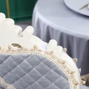Détail d'une housse de dossier de chaise en velours gris avec dentelle et élastique