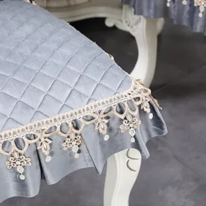 Gros plan d'un coussin de chaise en velours gris avec dentelle dorée et matelassage élégant