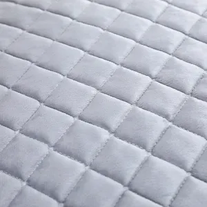 Gros plan sur le tissu en velours matelassé gris avec motif en losange et texture douce