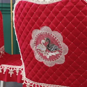 Vue détaillée de la housse de chaise rouge matelassée avec cygnes brodés et dentelle