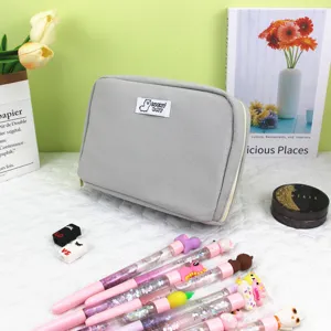 Grijze stoffen organizer tas met kleurrijke glitterpennen voor schoolspullen
