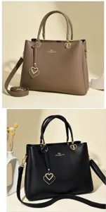 Detail view of stylish leather tote bags in black and brown with elegant gold heart charms