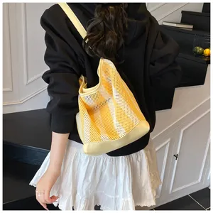 Vista posterior de modelo con bolso de malla a rayas amarillas y blancas para vacaciones