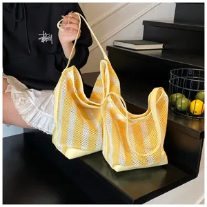 Detalle de bolsos de malla con rayas amarillas y diseño hueco transpirable de moda
