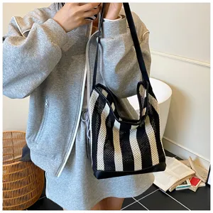 Primer plano de un bolso de hombro calado a rayas para un estilo informal y relajado.