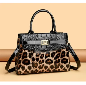 Close-up of leopard print handbag with black crocodile texture and floral lock