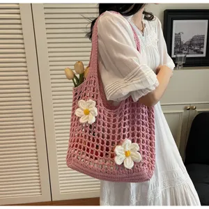 Primer plano detallado de un bolso tote de malla rosa con flores blancas decorativas