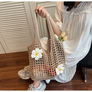 Vista detallada de un elegante bolso tote de ganchillo con detalles de flores blancas