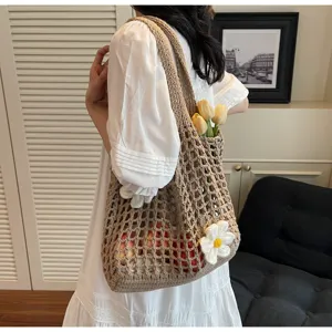 Detalle de un bolso tote de malla tejido a mano con una elegante decoración de flores