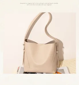 Minimalist cream leather bucket bag styled on a lifestyle magazine and white backdrop.