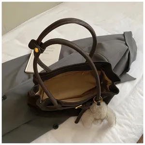 Detail shot of large capacity brown suede tote bag with plush rabbit charm
