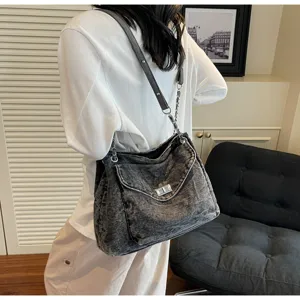 Vue détaillée d'un sac cabas en denim lavé avec bandoulière chaîne et verrou doré