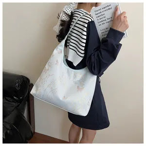 Photo de style de vie d'un sac cabas brodé avec des motifs de papillon et de bambou.