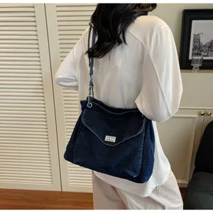 Grand sac cabas en denim bleu délavé avec chaîne argentée et fermoir métallique