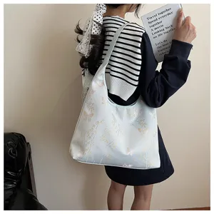 Vue détaillée d'un sac cabas brodé bleu clair avec des motifs de papillons et de bambous